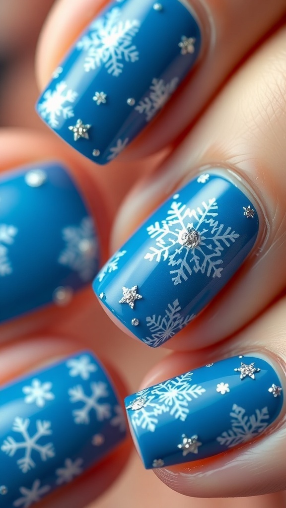 Elegant blue Christmas nails with snowflake designs and glitter accents.